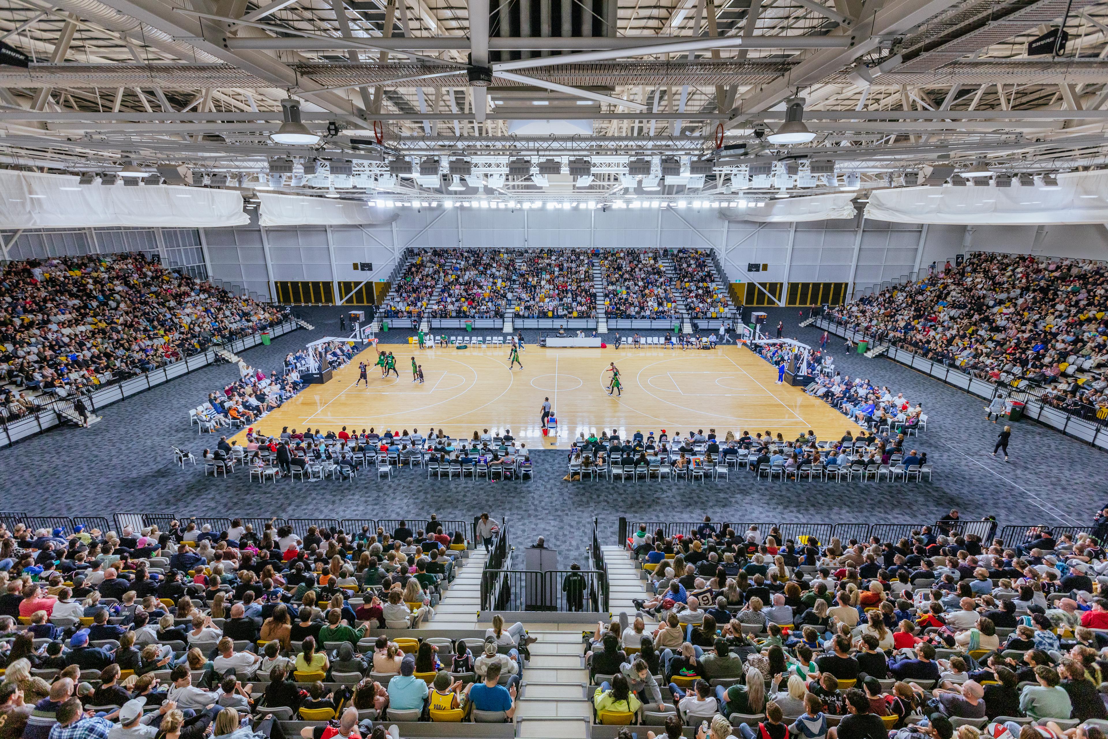 Large crowd in an indoor stadium watching a basketball game