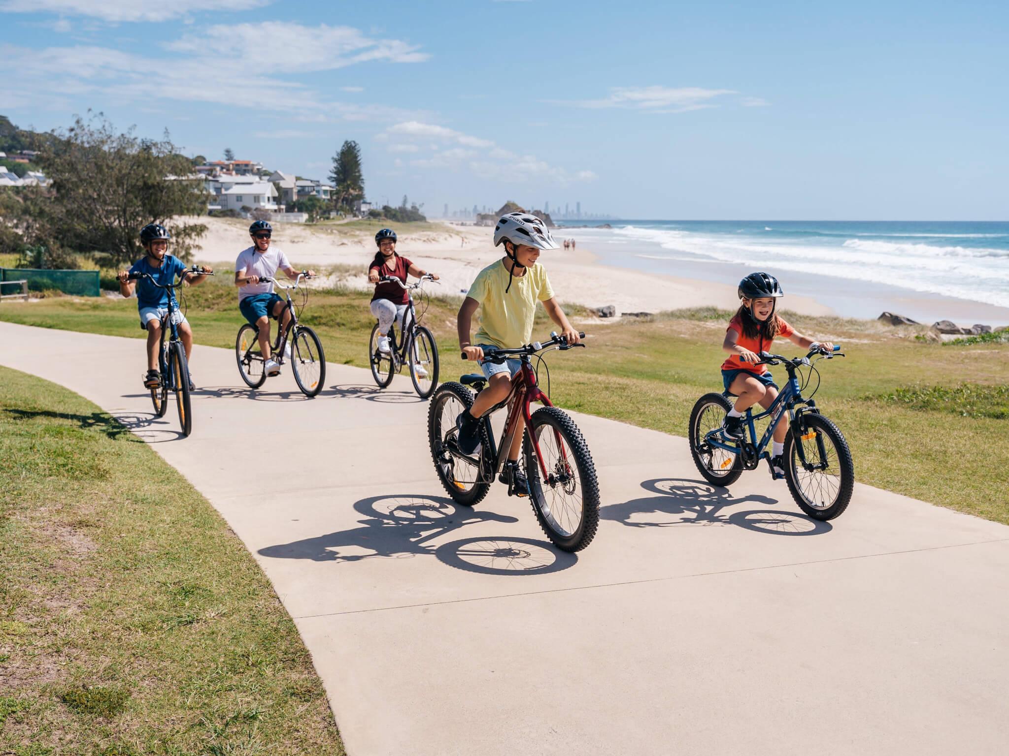 Cyclists riding along a beachside path.